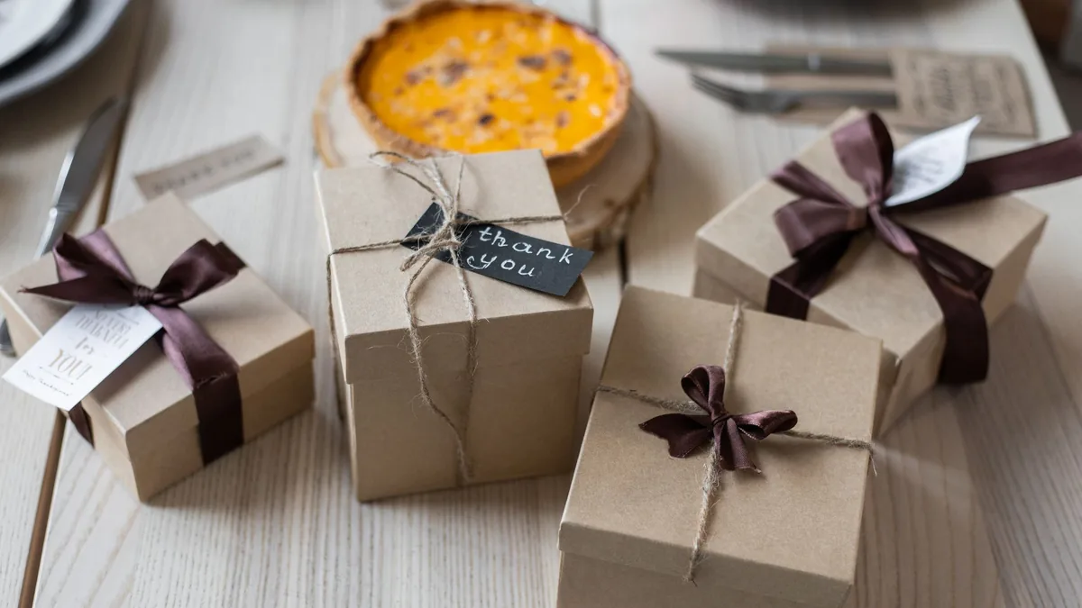 Several small kraft-paper gift boxes tied with ribbon and twine, with handwritten tags, set on a light wooden table