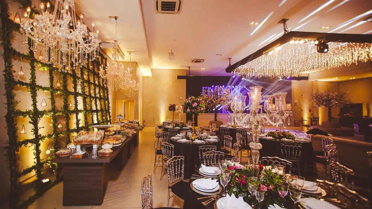 Empty banquet hall set for a wedding reception, with crystal chandeliers, floral centrepieces and laid dining tables
