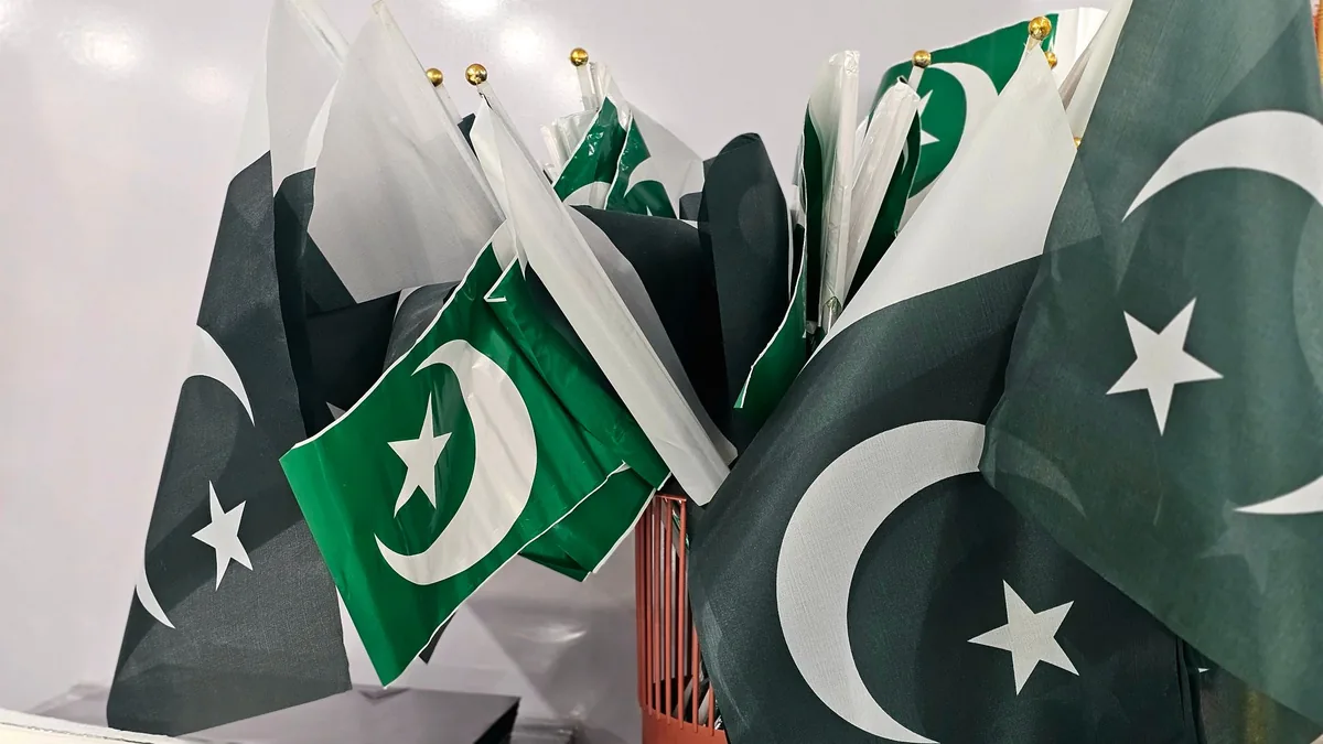 A bundle of small green and white Pakistani flags with crescent and star, grouped together on sticks