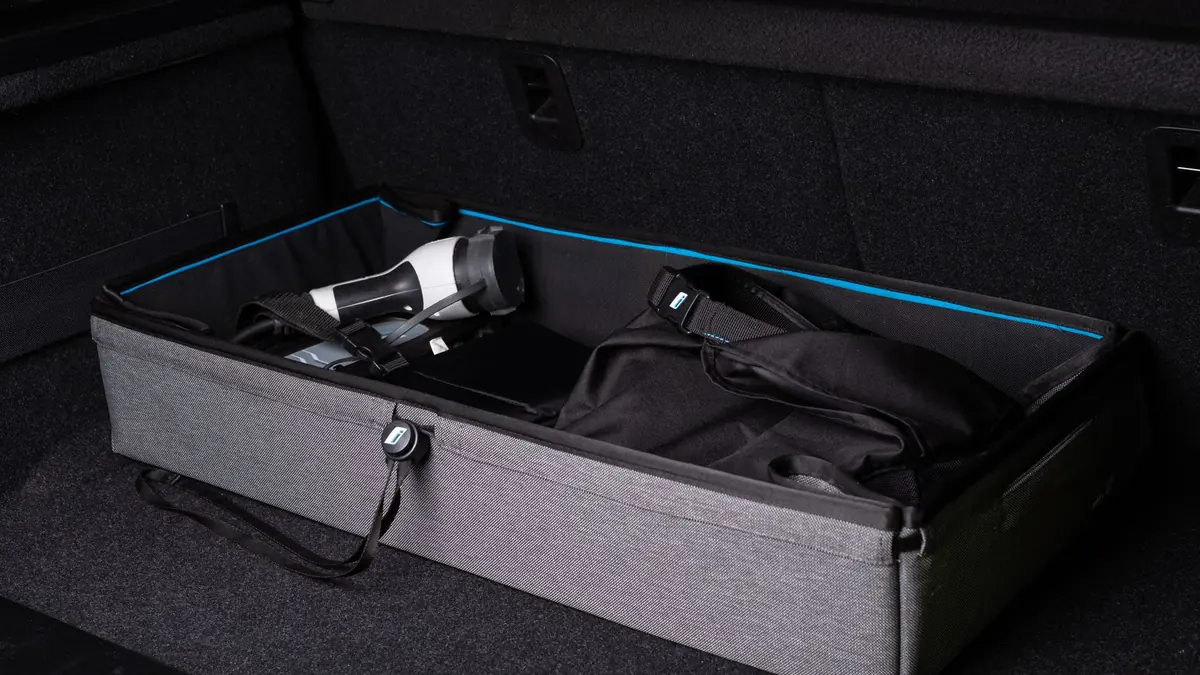 Open car boot with a grey storage organiser holding travel bags and gear, ready for a trip to the airport