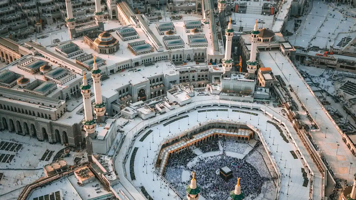 Aerial view of the Grand Mosque in Makkah, pilgrims circling the Kaaba in the central courtyard amid surrounding galleries