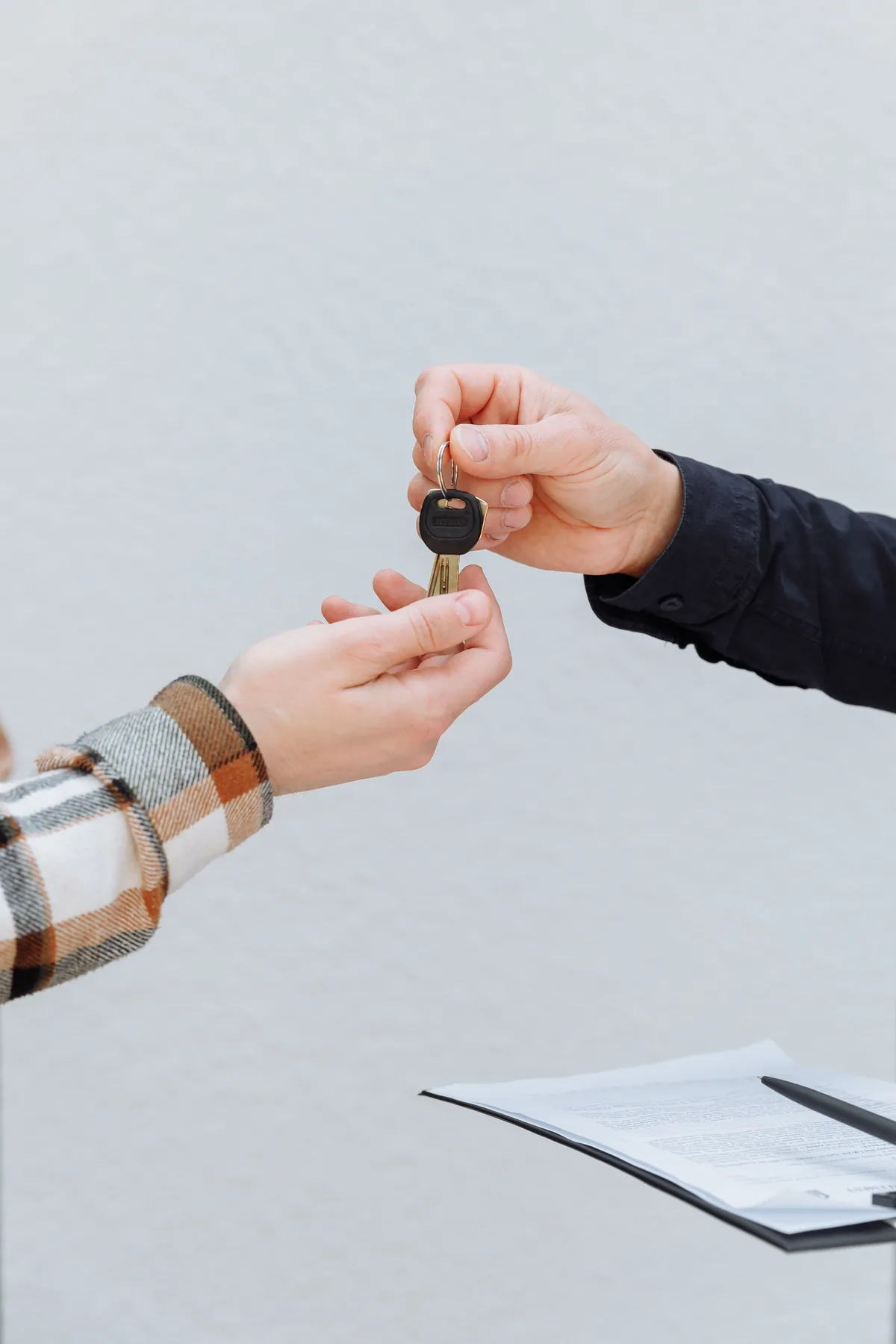 Handing over the car keys Close-up of two hands exchanging a car key