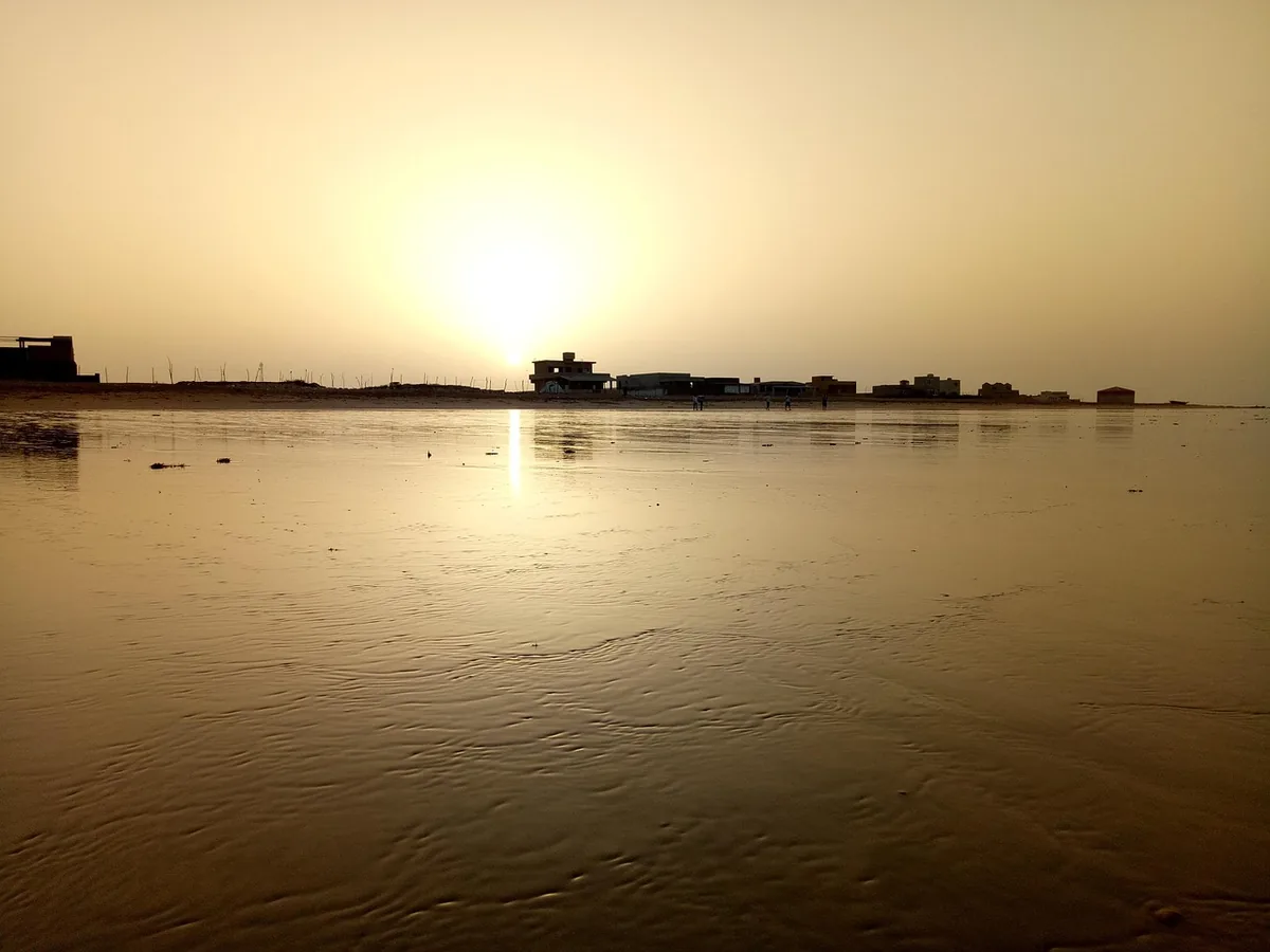 Low sunlight reflected on calm coastal water near Karachi