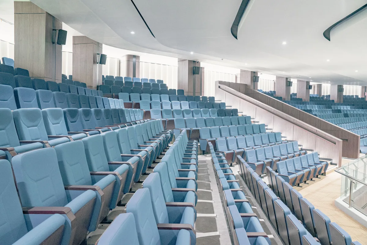 Rows of blue seats in an empty auditorium
