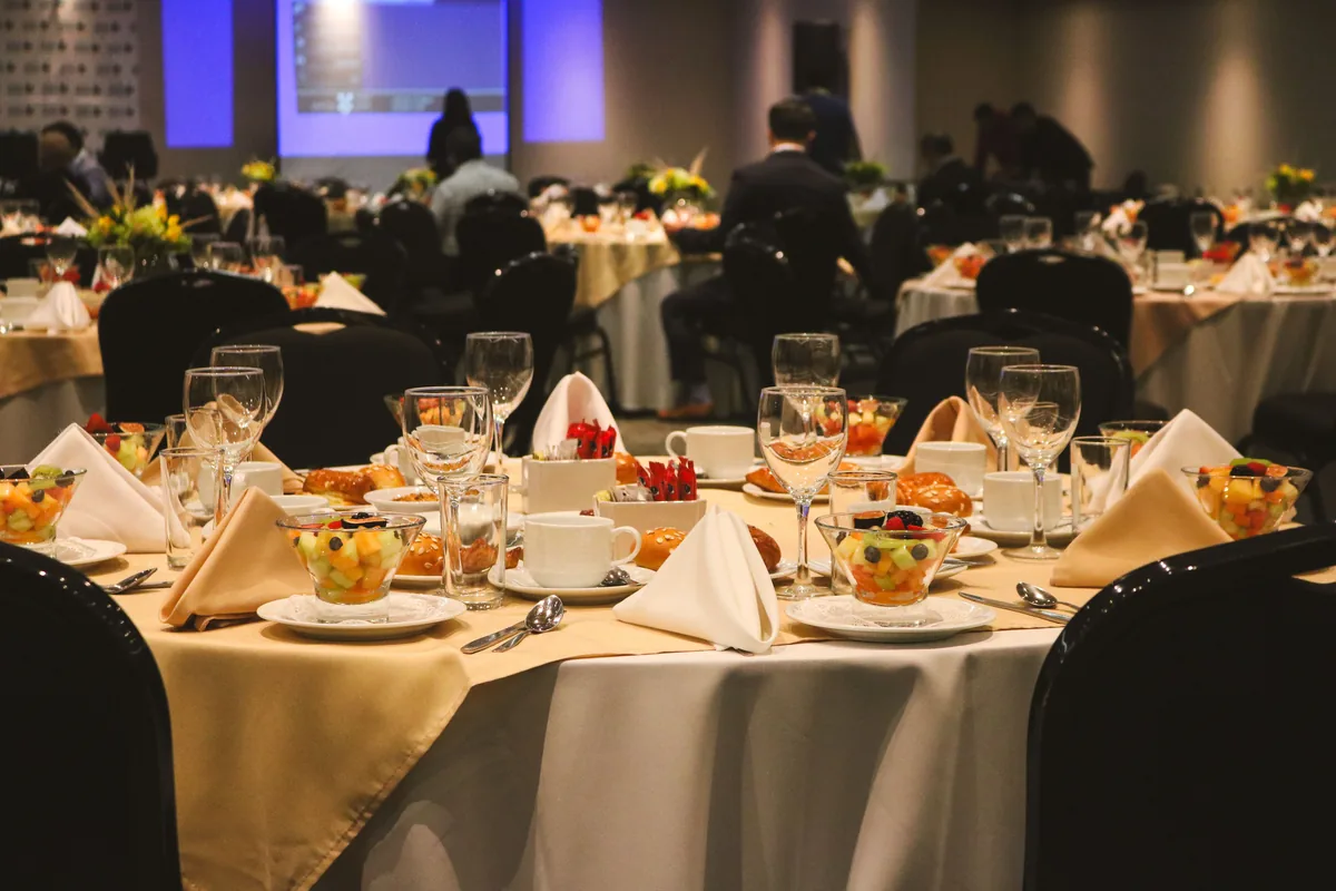 Round tables set for guests in a banquet room