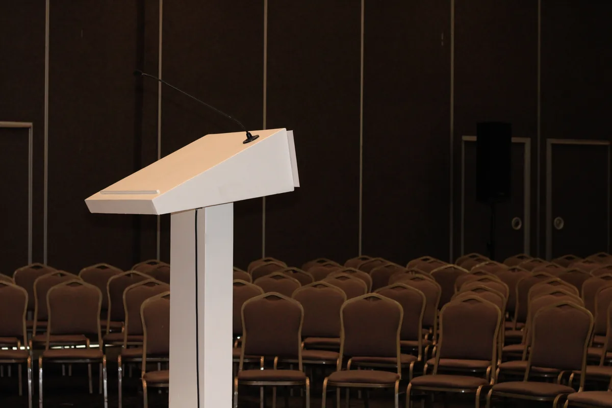 Conference podium Podium at the front of a room prepared with rows of chairs