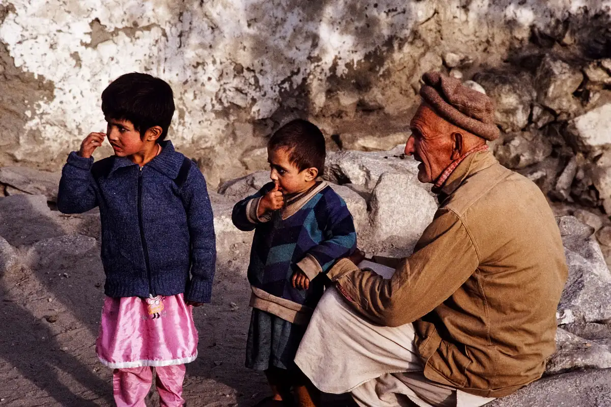 Family conversation outdoors An older man sits beside two children outdoors