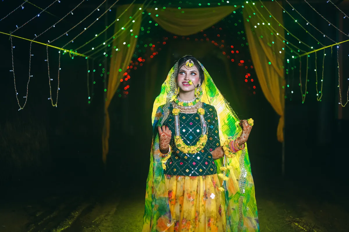 Person in bright traditional clothes beneath event lights