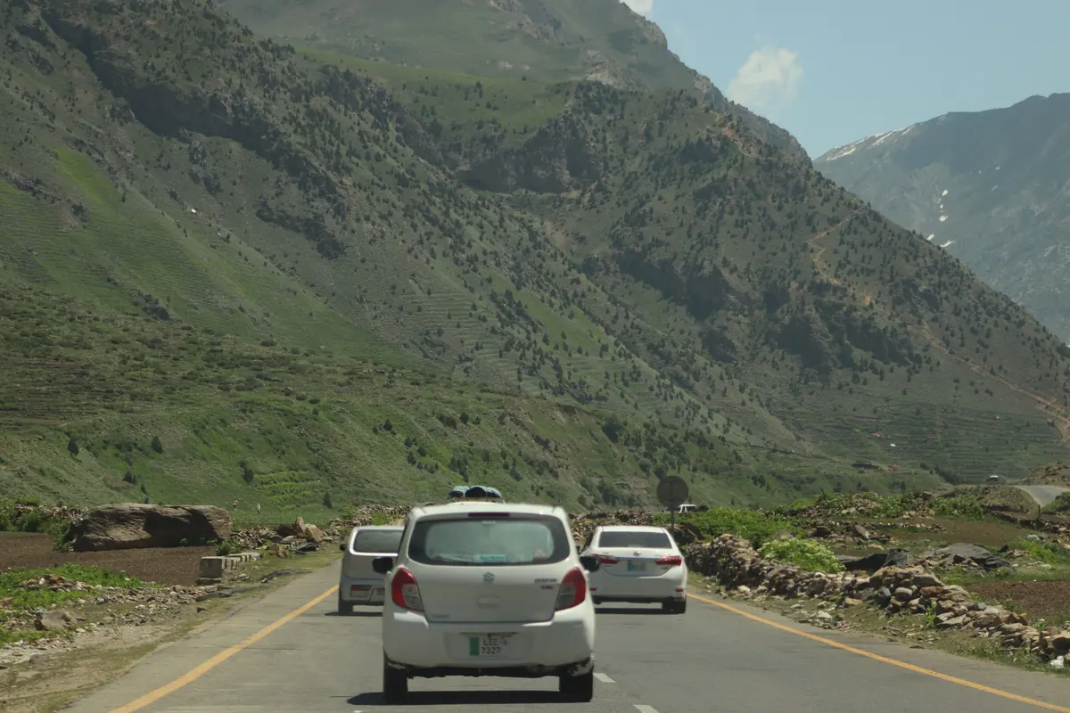 Cars on a mountain road Two cars travelling on a road through green hills