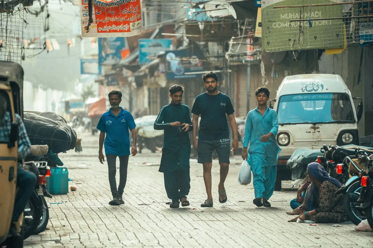 People walking along a busy street in Karachi