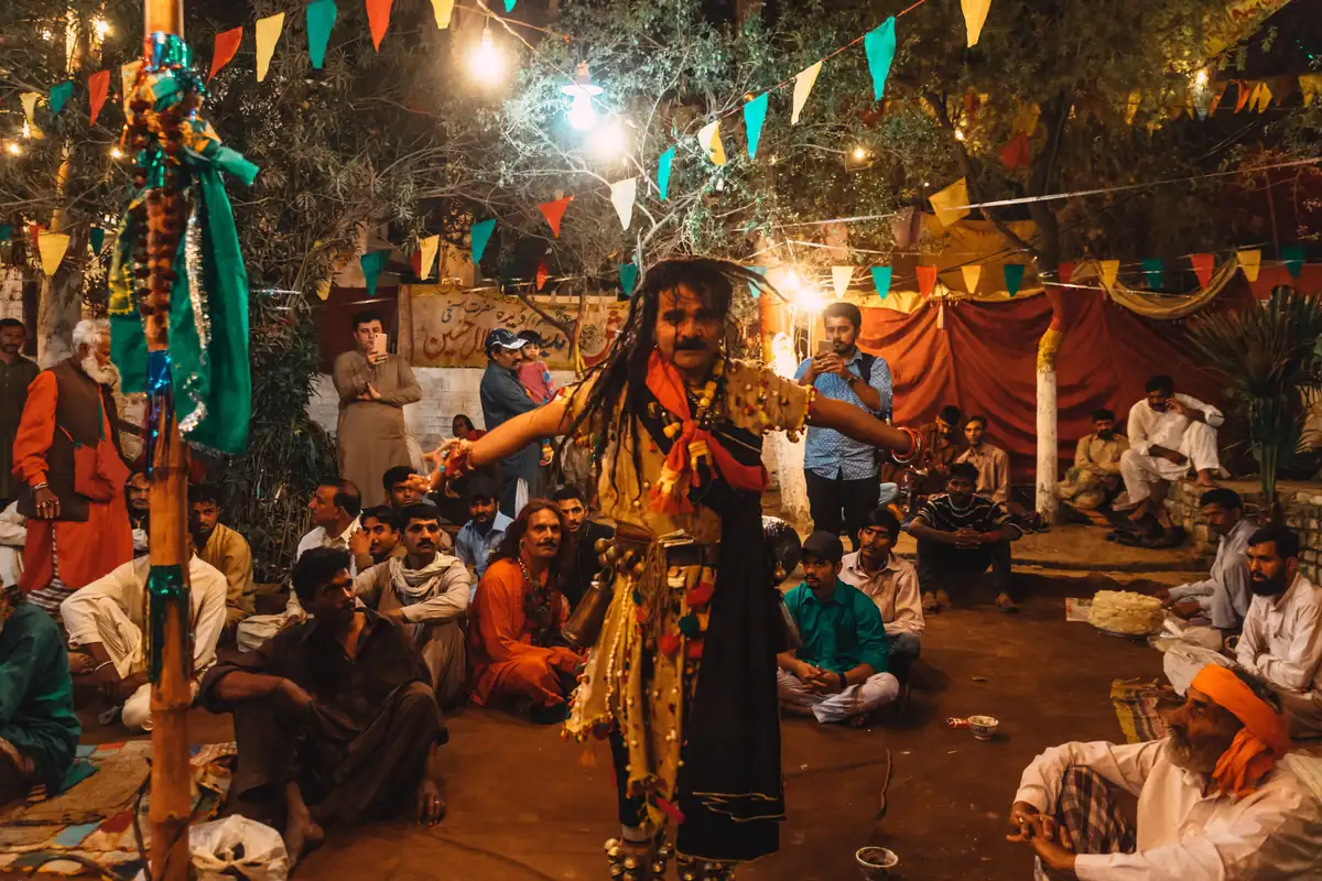 People gathered around a performer during a lit evening celebration