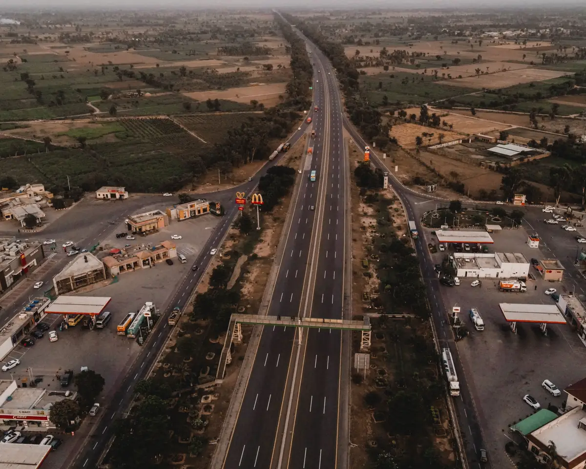 Divided road running through fields and roadside buildings