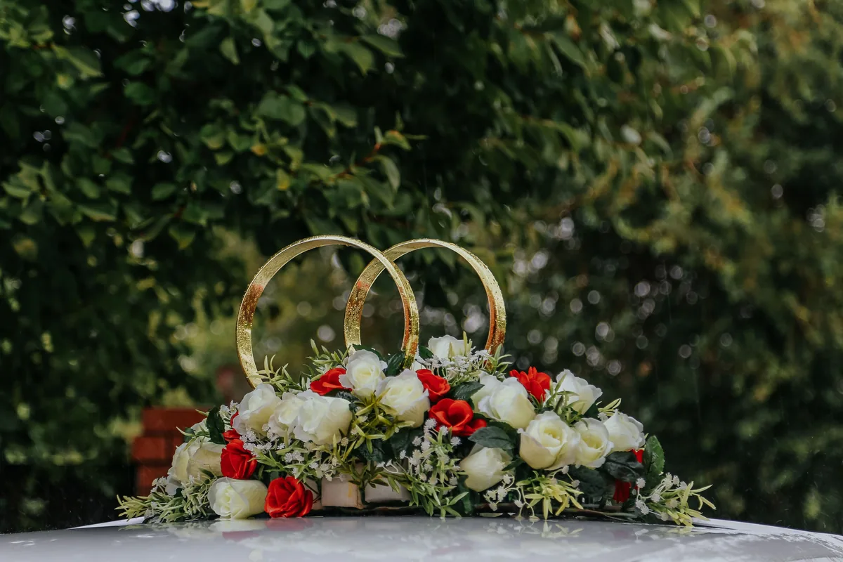 Wedding car floral decoration Floral rings and flowers displayed on a vehicle bonnet